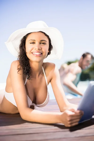 Woman in hat using digital tablet