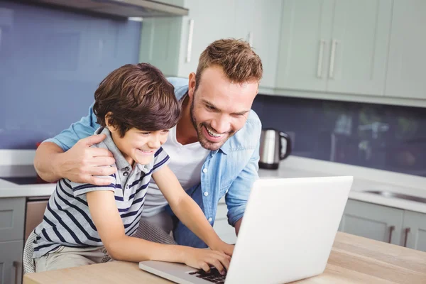 Father and son working on laptop