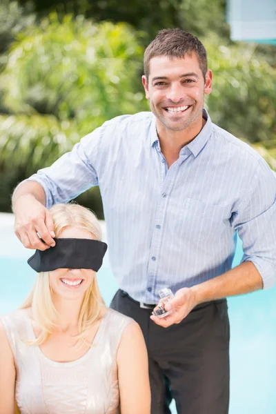 Man blindfolding woman