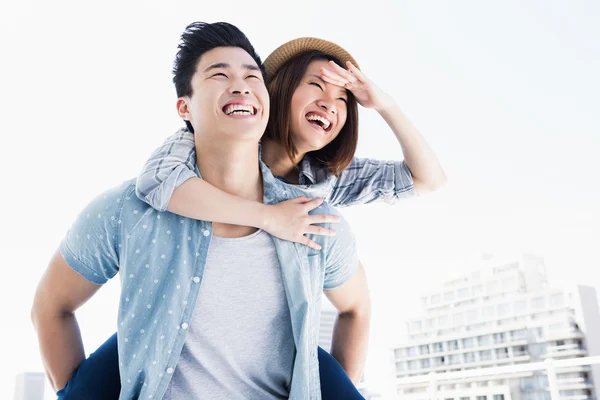 Man giving piggyback ride to woman