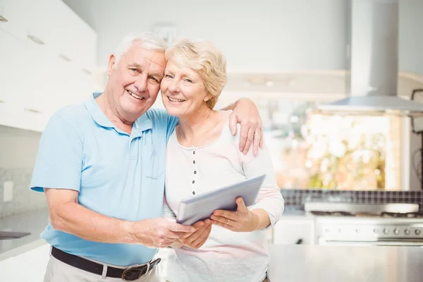 Senior couple holding tablet in kitchen