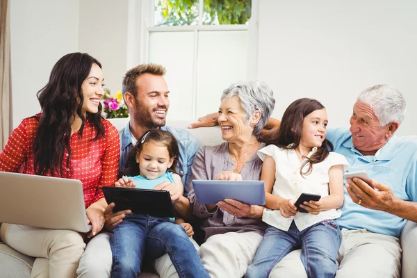 Family smiling while holding technologies