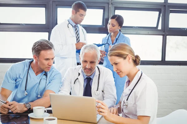 Medical team using laptop in conference room