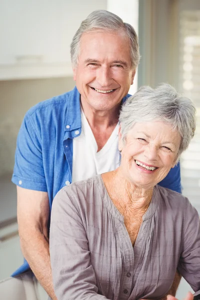 Portrait of happy senior man embracing wife