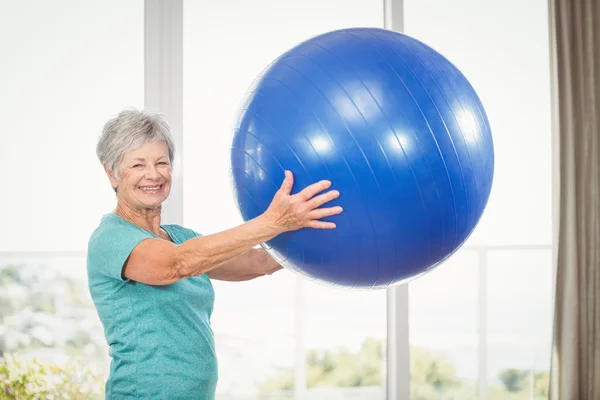 Smiling senior woman holding exercise ball