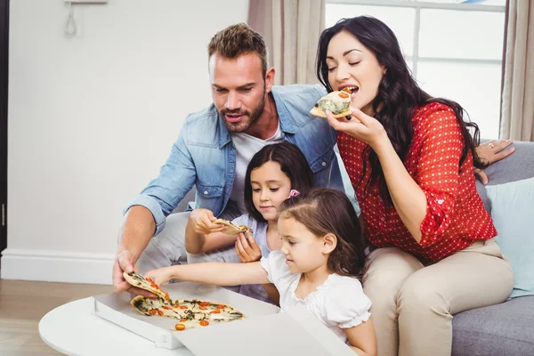 Family of four eating pizza