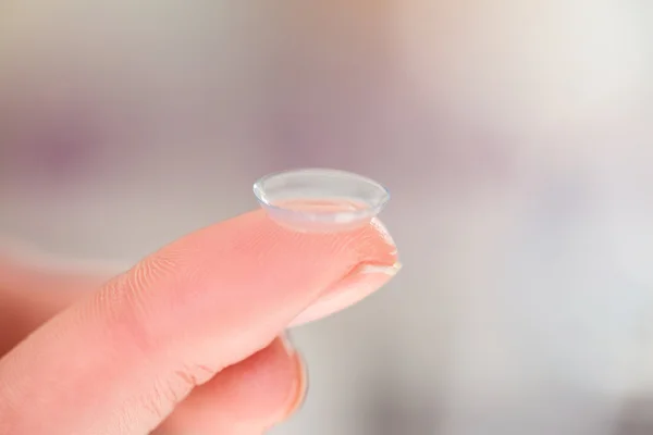 Hand holding contact lens
