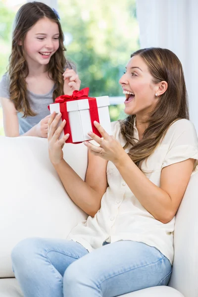 Surprised woman holding gift with daughter