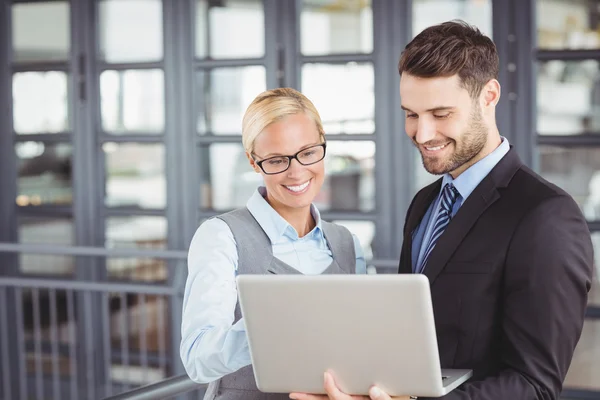 Business people looking at laptop