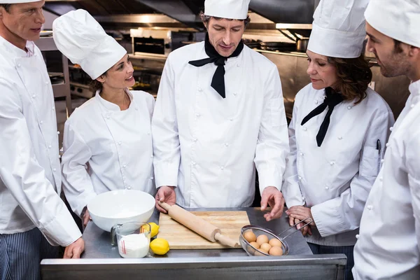 Chef teaching team to prepare dough