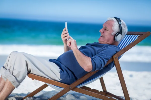 Mature man resting on a deck chair
