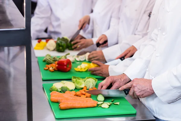 Close-up of chefs chopping vegetables