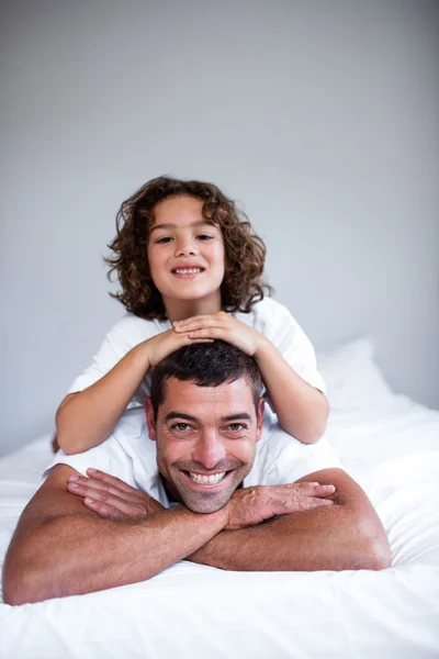 Son lying on fathers back