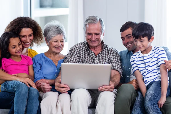 Happy family using laptop on sofa