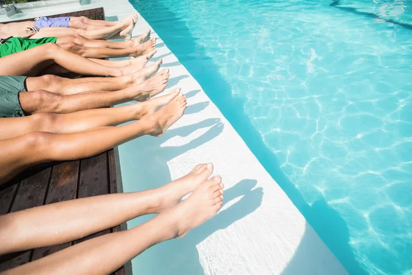 Feet of friends relaxing at poolside