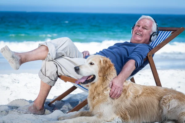 Man resting on a deck chair listening to music