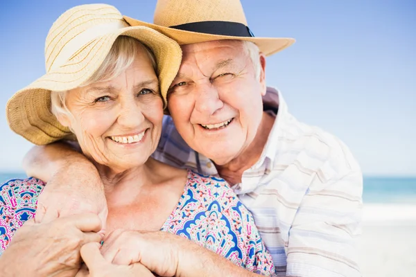 Senior couple with hat embracing