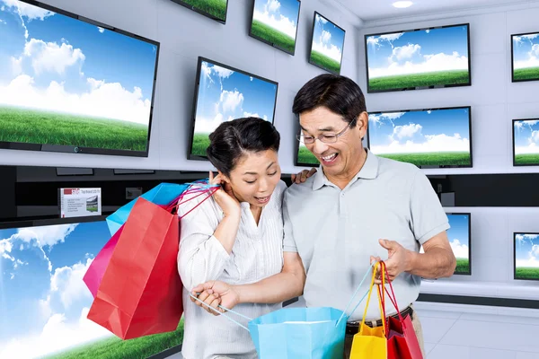 Older asian couple with shopping bags