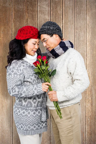 Older asian man giving his wife flowers