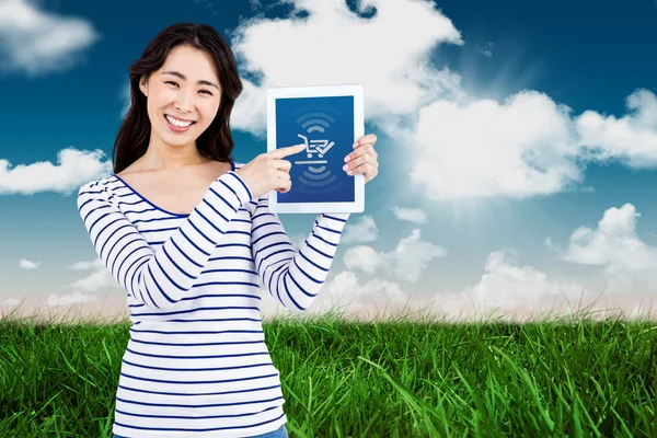 Cheerful woman pointing at tablet computer