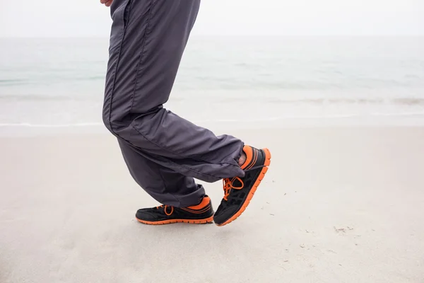 Man\'s foot while jogging on beach