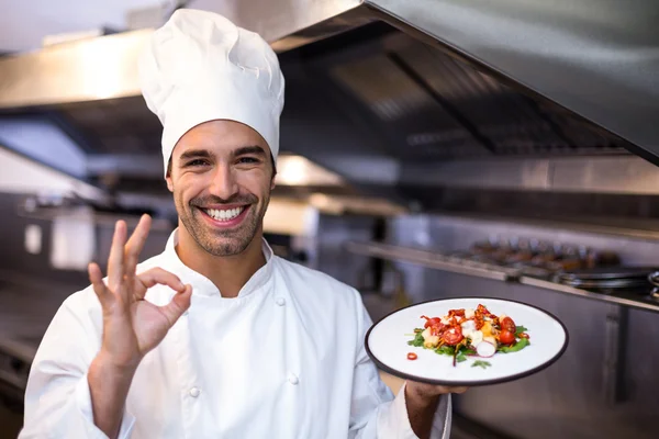 Handsome chef showing ok sign and meal