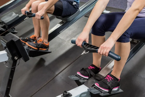 People exercising on rowing machine