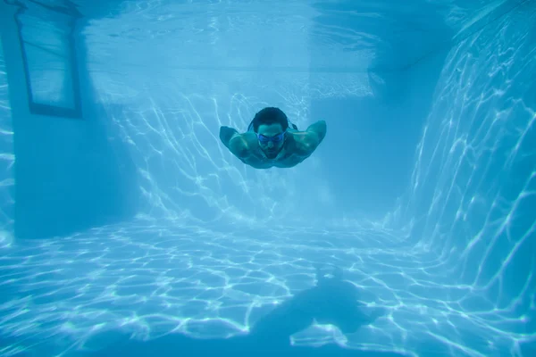 Man swimming underwater at resort