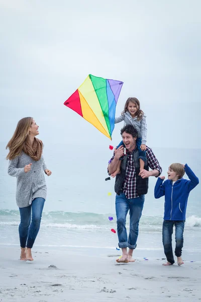 family with kite enjoying at sea shore