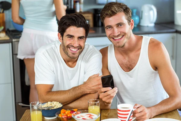 Happy men holding mobile phone