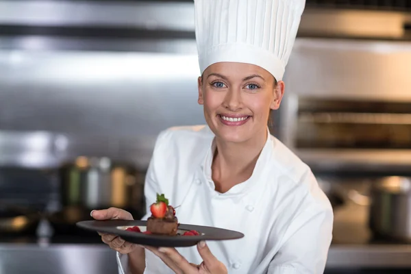 Chef holding plate in commercial kitchen