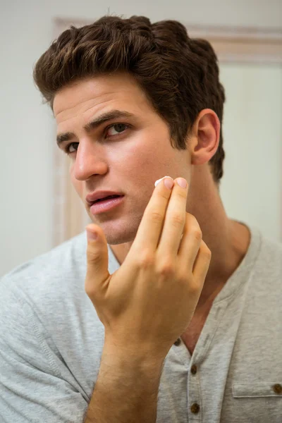 Man applying moisturizer on face