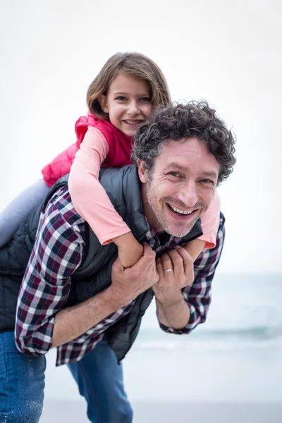 Father carrying daughter on back