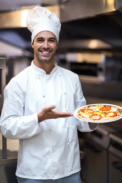 Handsome chef presenting pizza