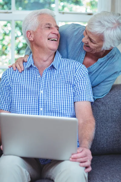 Smiling retired couple using laptop