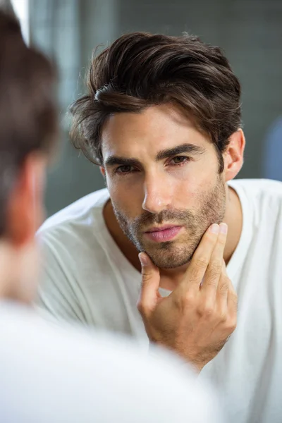 Man checking stubble in bathroom