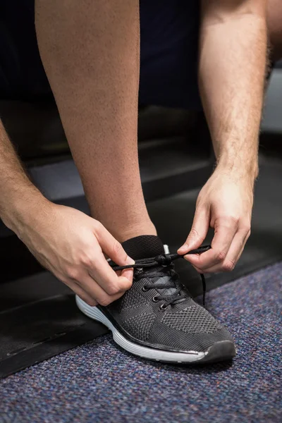 Man tying up his shoe lace