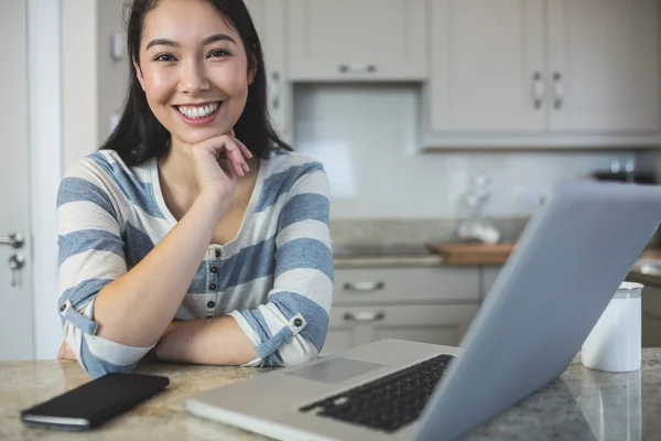 Woman sitting with laptop and phone