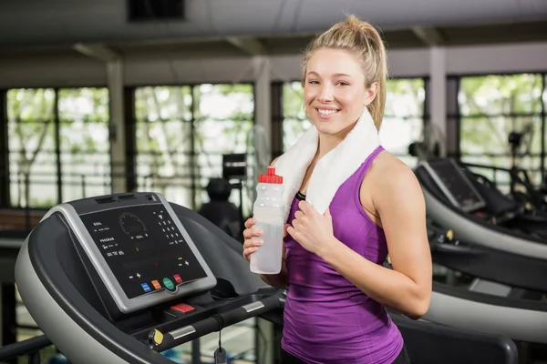 Woman on treadmill holding water bottle