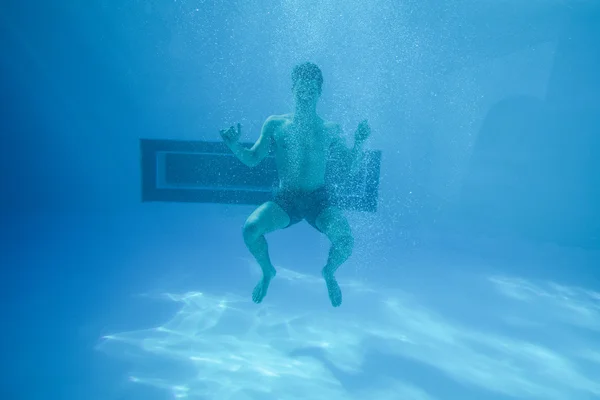 Man swimming underwater at resort