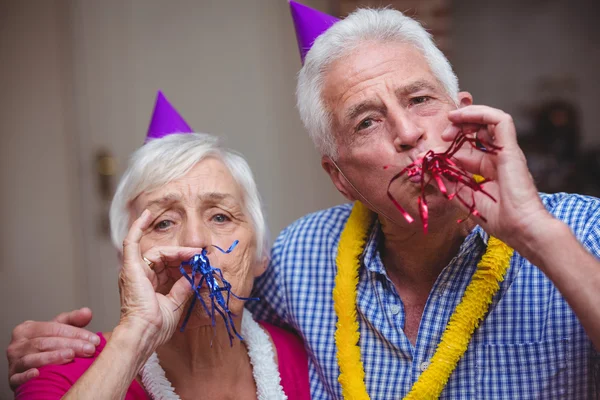 Couple blowing party horns