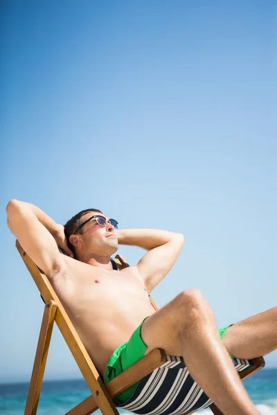 Man sitting and relaxing on deck chair