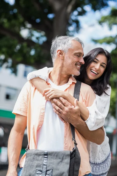 Happy woman embracing man from behind