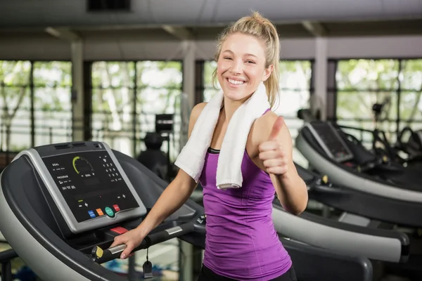 Woman showing thumbs up at gym