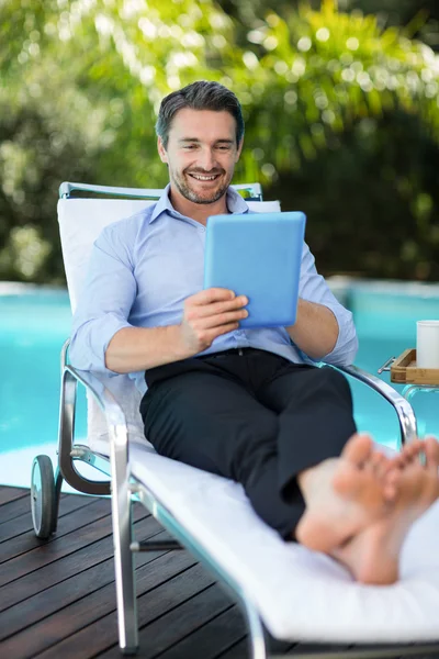 man using digital tablet near pool