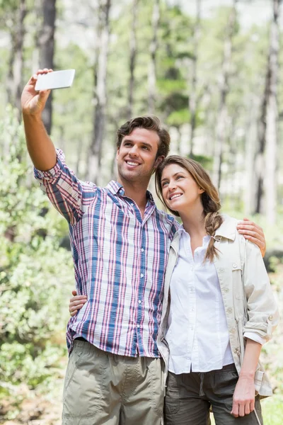 Couple with arms around clicking selfie