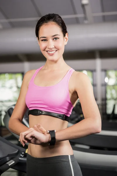 Woman using smart watch on treadmill