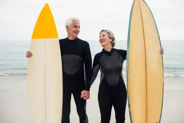 Senior couple with surfboard