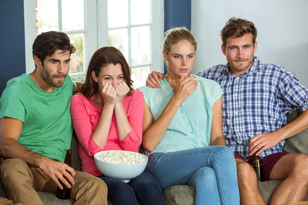 Friends watching football match at home