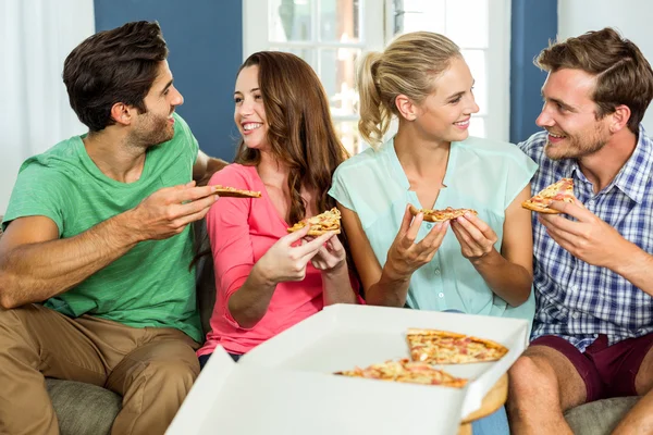 Smiling friends enjoying pizza